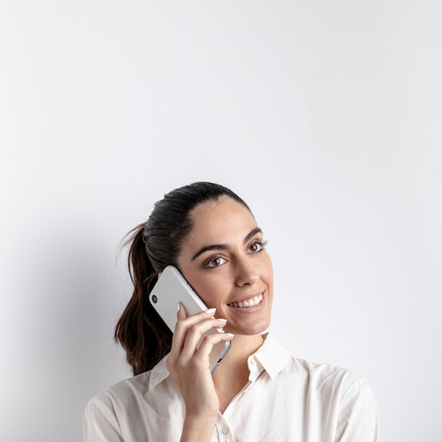 Foto gratuita mujer sonriente posando con smartphone