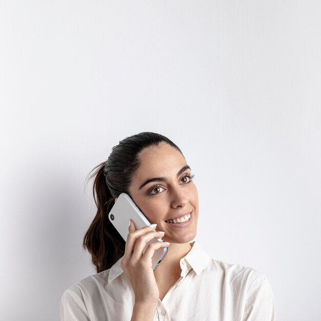 Mujer sonriente posando con smartphone