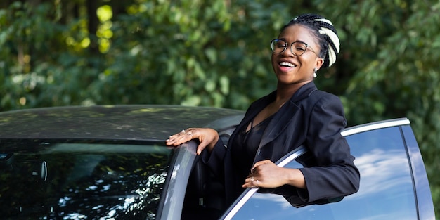 Mujer sonriente posando con su coche nuevo