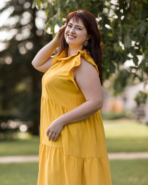 Mujer sonriente posando con un vestido amarillo