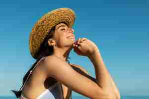 Foto gratuita mujer sonriente posando en la vista lateral de la playa