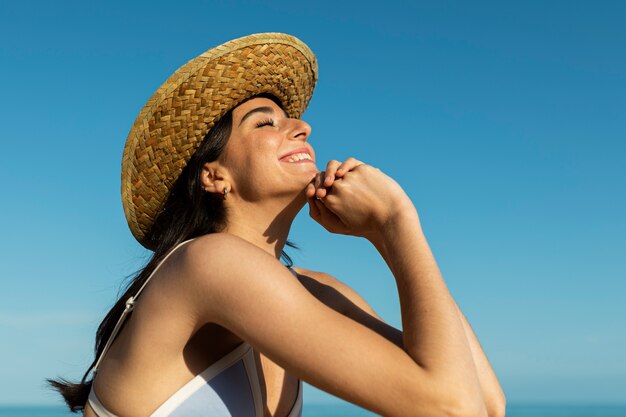 Mujer sonriente posando en la vista lateral de la playa