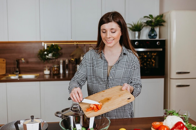 Mujer sonriente preparando comida en la cocina