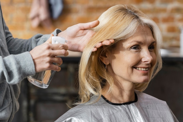 Mujer sonriente preparándose para un corte de pelo en casa