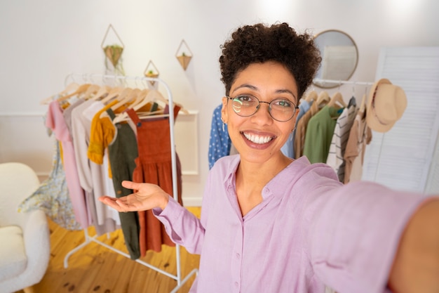 Foto gratuita mujer sonriente presentando ropa tiro medio