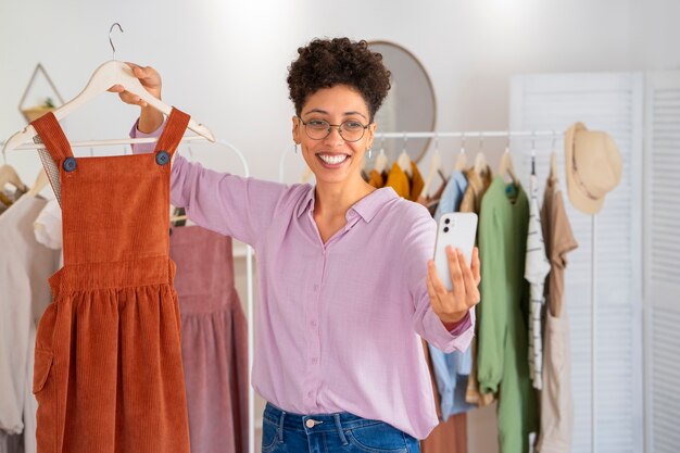 Mujer sonriente presentando ropa vista frontal