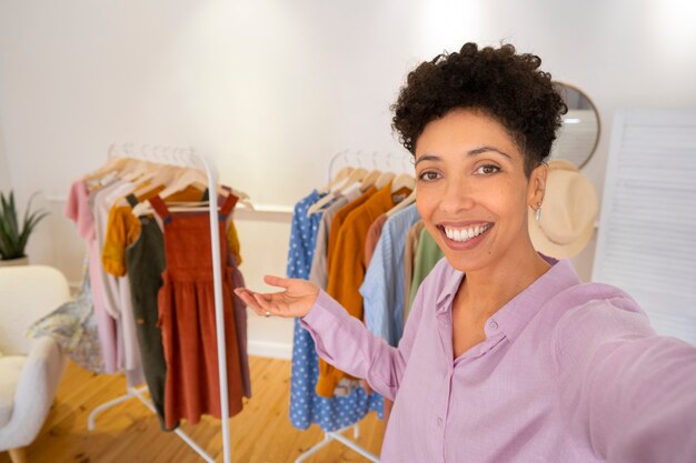 Mujer sonriente presentando ropa vista frontal