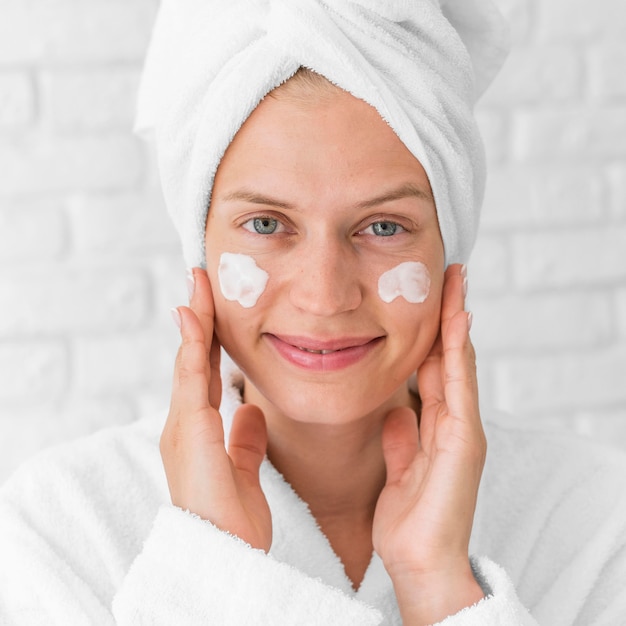 Mujer sonriente de primer plano con crema facial