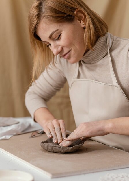 Mujer sonriente de primer plano haciendo cerámica