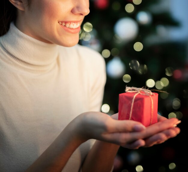 Mujer sonriente de primer plano con pequeño regalo