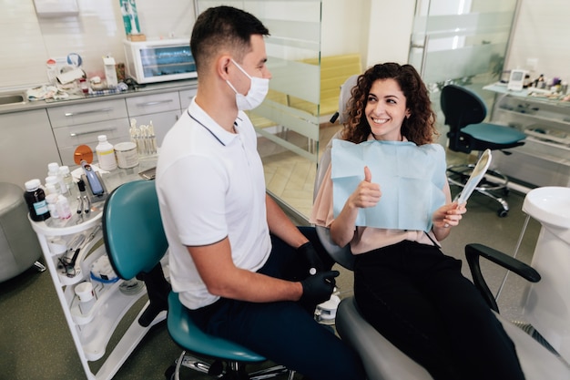 Mujer sonriente que aprueba el trabajo dental