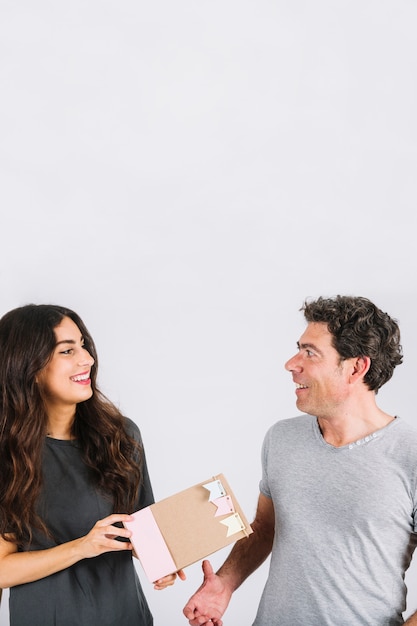 Mujer sonriente que da el regalo al padre