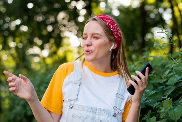 Mujer sonriente que disfruta de música al aire libre