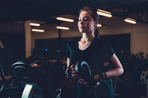 Mujer sonriente que ejercita en gimnasio