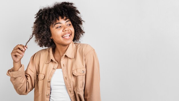 Mujer sonriente que juega con su pelo