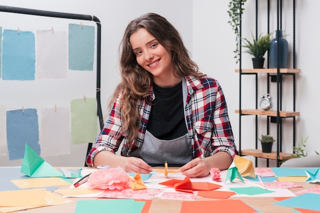 Mujer sonriente que mira la cámara mientras que hace el arte