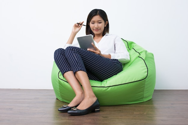 Mujer sonriente que mira a través de los datos sobre su touchpad