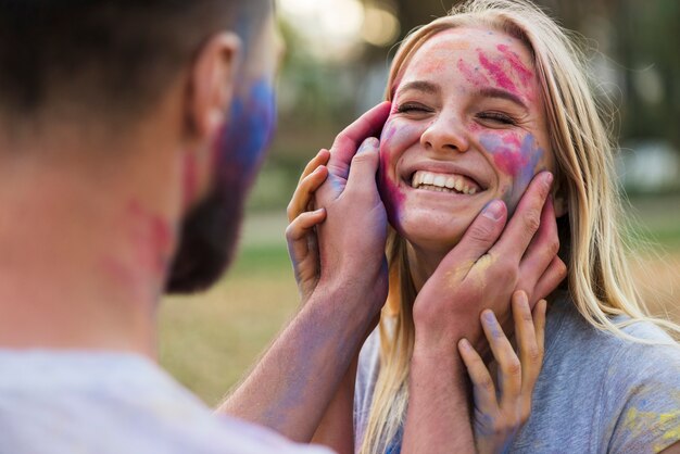 Mujer sonriente que presenta con la cara coloreada