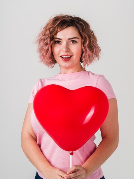 Mujer sonriente que presenta con el globo