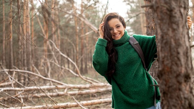 Mujer sonriente que sostiene en árbol