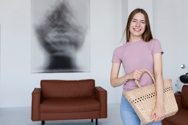 Mujer sonriente que sostiene una bolsa linda