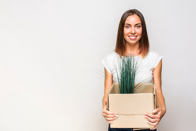 Mujer sonriente que sostiene una caja con copyspace