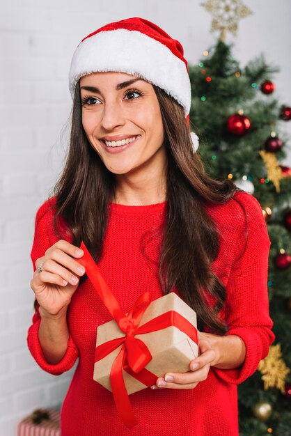 Mujer sonriente que sostiene la caja de regalo