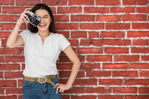 Mujer sonriente que sostiene una cámara
