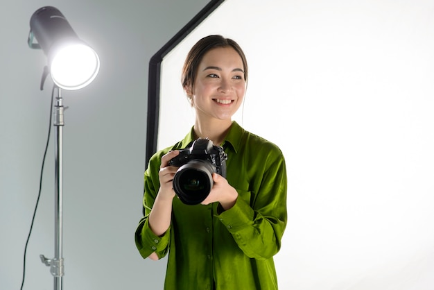 Mujer sonriente que sostiene la cámara