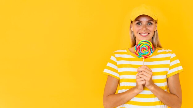 Mujer sonriente que sostiene el caramelo