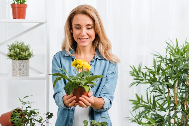 Mujer sonriente que sostiene las flores