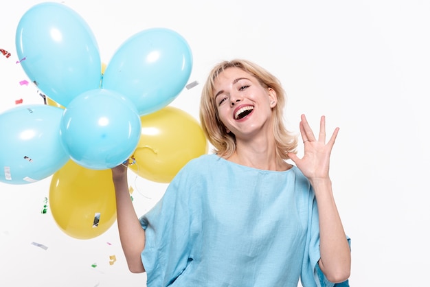 Mujer sonriente que sostiene los globos