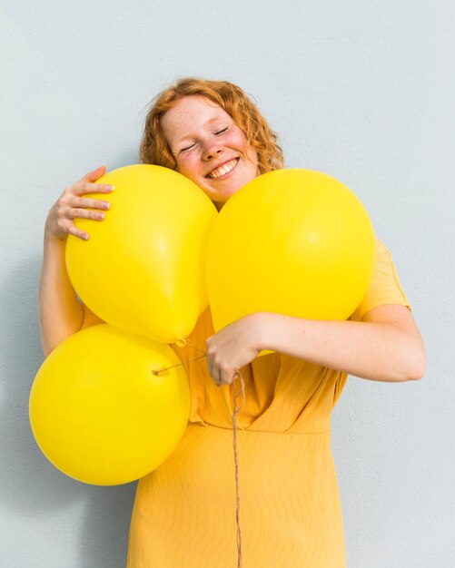 Mujer sonriente que sostiene los globos