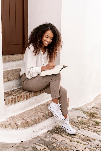 Foto gratuita mujer sonriente que sostiene un libro abierto