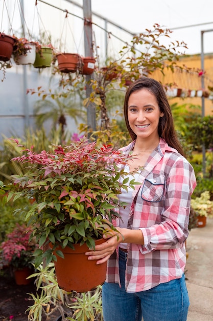 Mujer sonriente que sostiene la maceta grande