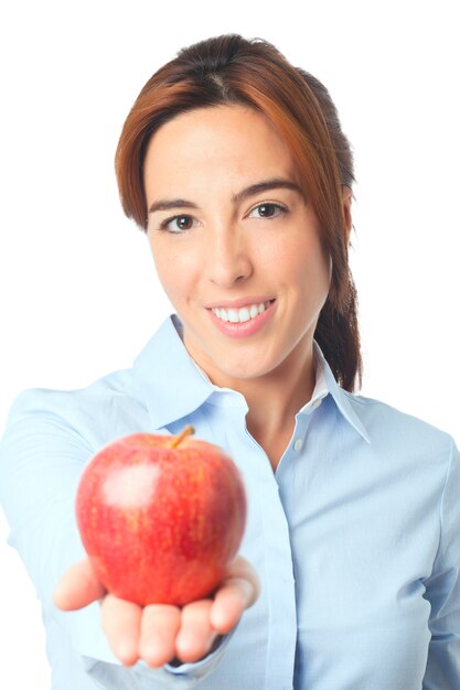 Mujer sonriente que sostiene una manzana roja