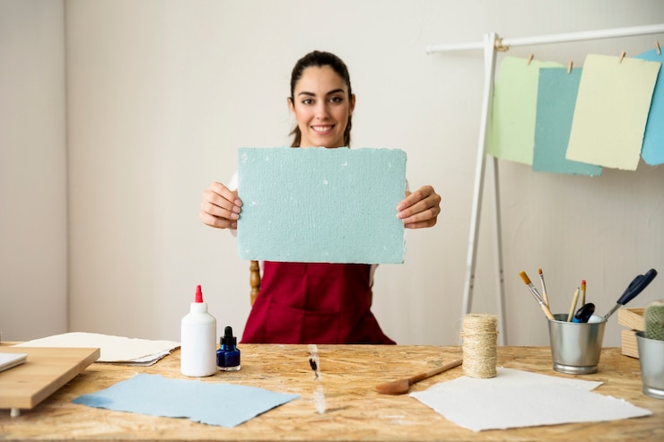 Foto gratuito mujer sonriente que sostiene el papel azul hecho a mano
