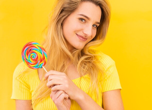 Mujer sonriente que sostiene la piruleta