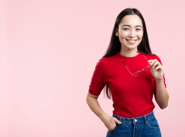 Mujer sonriente que sostiene los vidrios