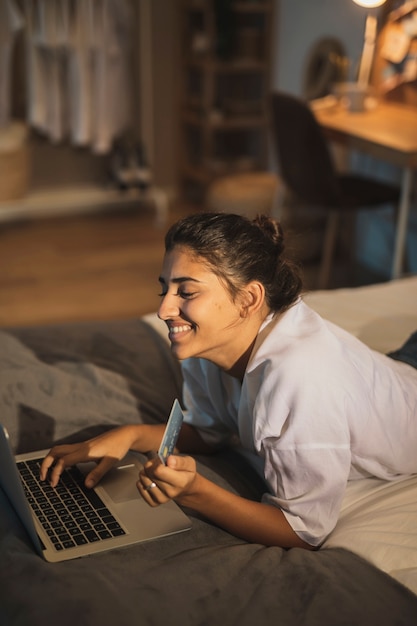 Mujer sonriente que trabaja en la computadora portátil de casa