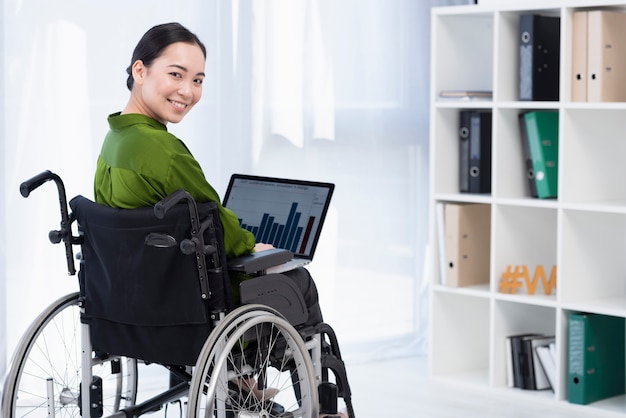 Mujer sonriente que trabaja en la computadora portátil