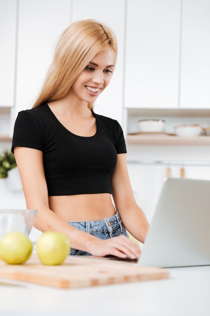 Mujer sonriente que usa la computadora portátil