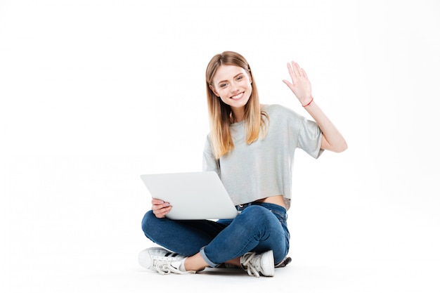Mujer sonriente que usa la computadora portátil