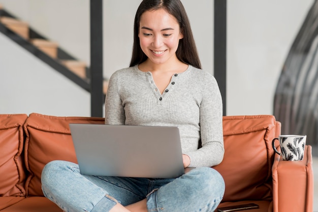 Mujer sonriente que usa la computadora portátil