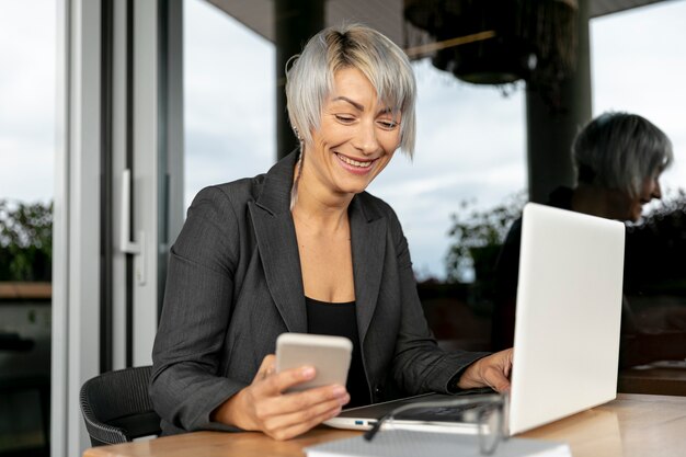 Mujer sonriente que usa dispositivos electrónicos