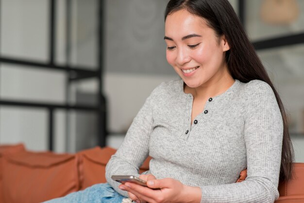 Foto gratuita mujer sonriente que usa el móvil