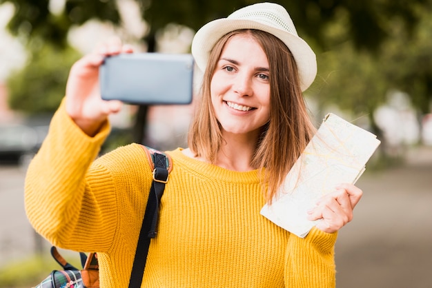 Mujer sonriente que viaja tomando un selfie
