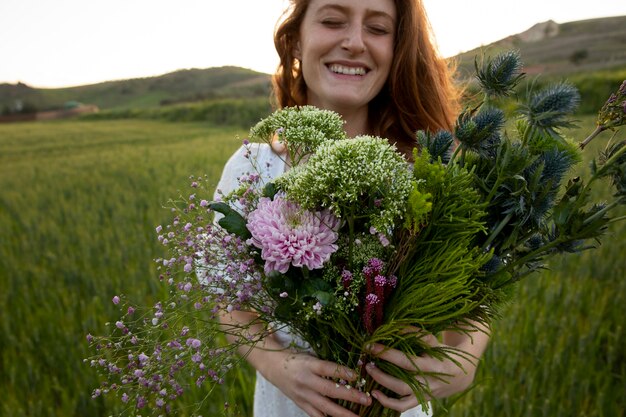 Mujer sonriente con ramo de flores vista frontal