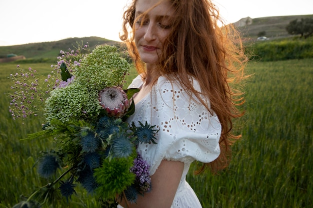 Foto gratuita mujer sonriente con ramo de flores vista lateral