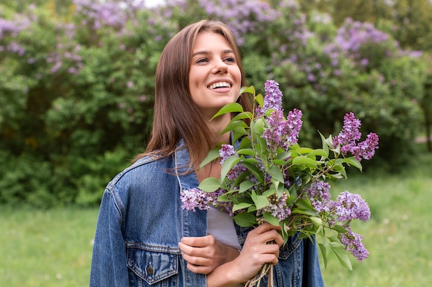 Mujer sonriente con ramo lila